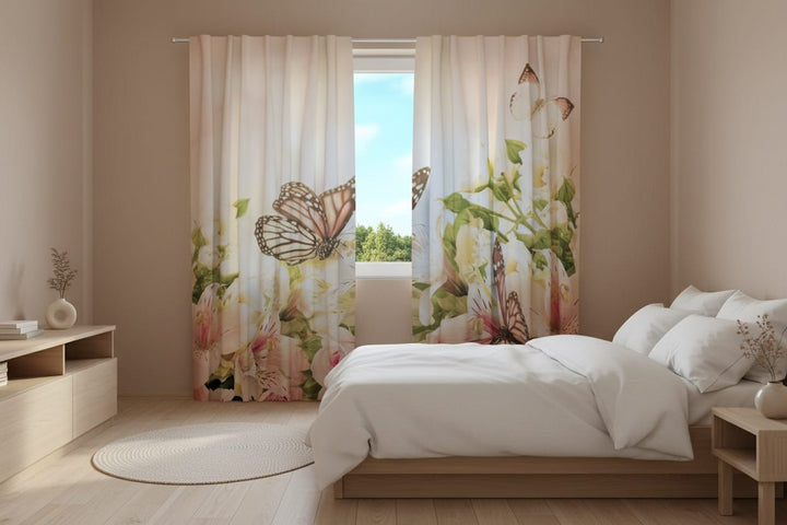 A bright bedroom interior featuring light-colored photo curtains in soft peach and pastel tones. The lower part of the curtains displays a photorealistic floral arrangement with white and pink lilies, roses, and green leaves, above which large butterflies flutter.