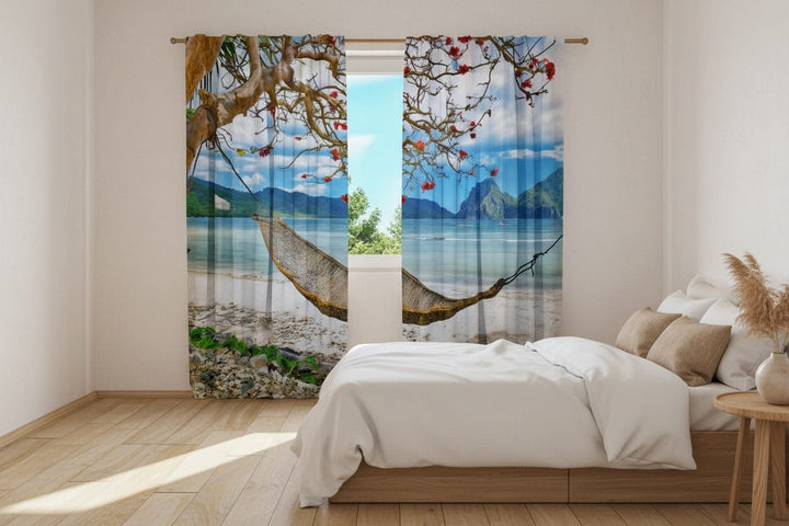 The living room interior features light-colored walls and a wooden floor. Photo curtains are hung on the window, featuring a photorealistic image of an exotic tropical beach.