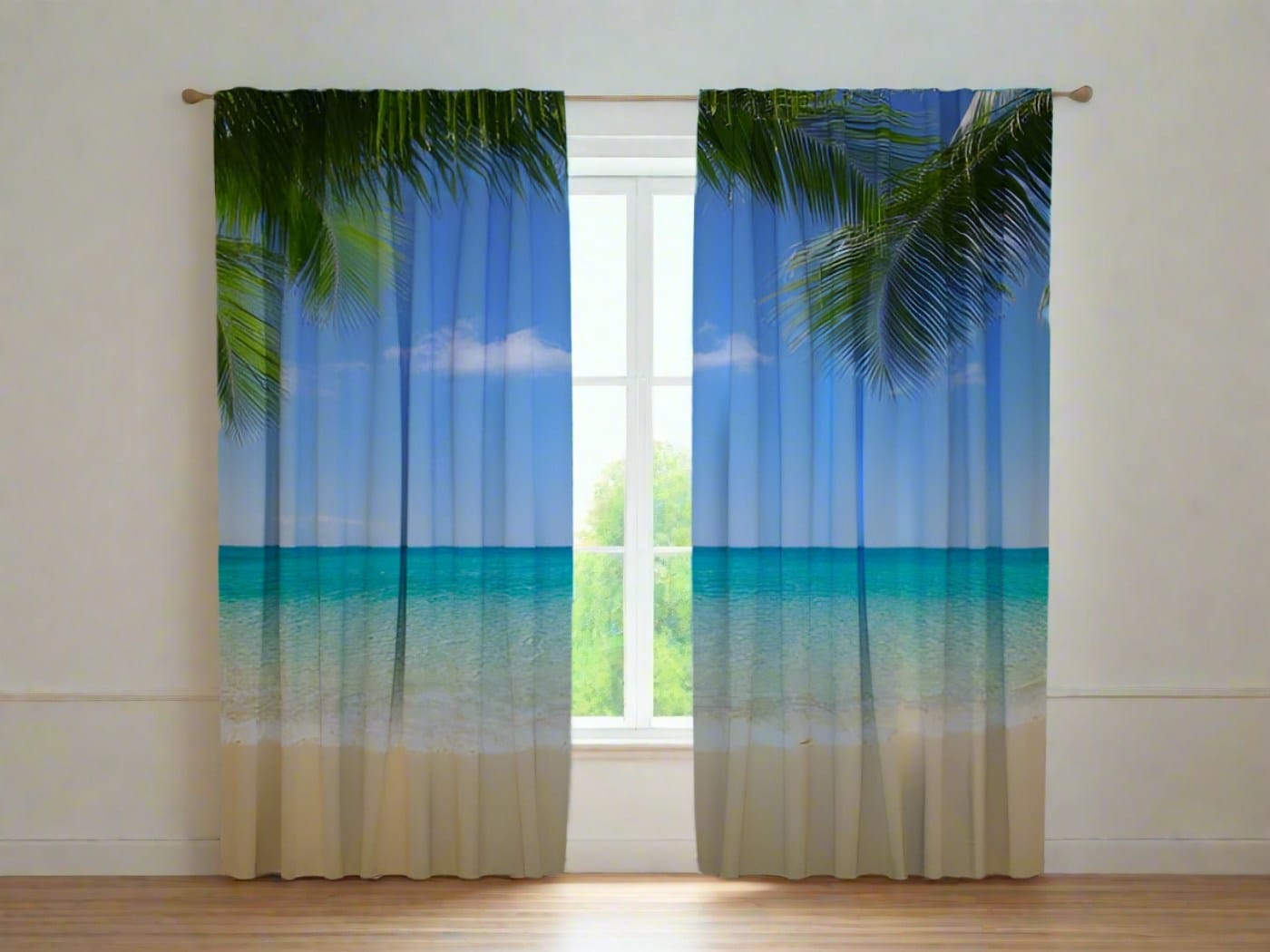 The interior of a bright room features white walls and a wooden floor. Photo curtains are hung on the window, depicting a photorealistic tropical summer beach. At the top of the curtains, large green palm leaves are visible against a bright blue sky. In the middle section, a calm, turquoise ocean unfolds, while the bottom section features light-colored sand. In the center of the open curtains, a white window frame is visible with a view of green nature.