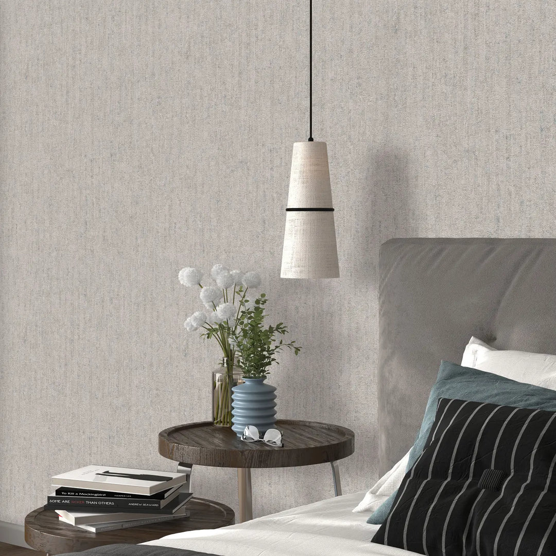Light gray relief-textured wallpaper in a bedroom interior with a wooden nightstand, books, a blue decorative vase, and white flowers