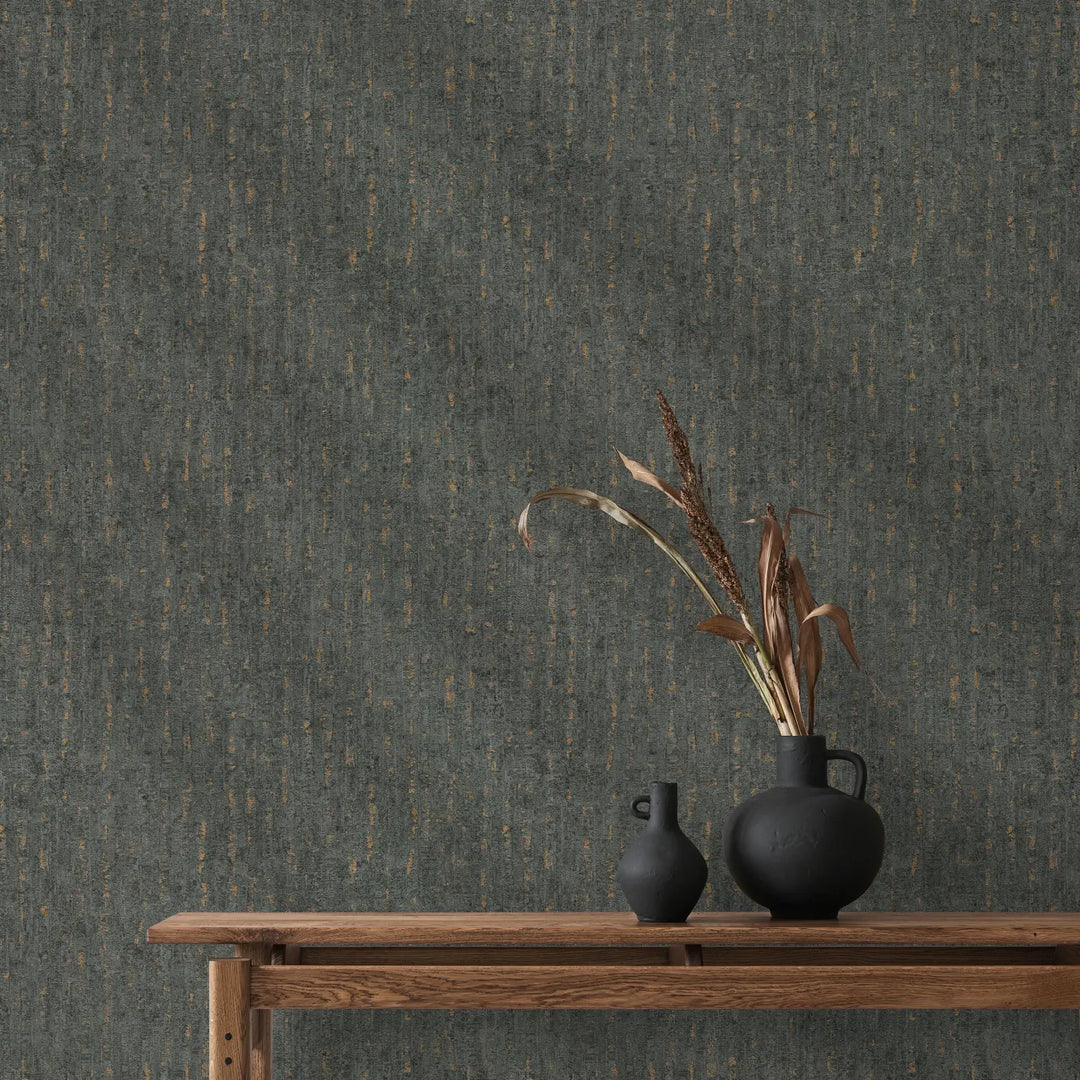 Dark gray wallpaper with vertical gold accents in an interior with a wooden console table, matte black decorative vases, and dried botanicals