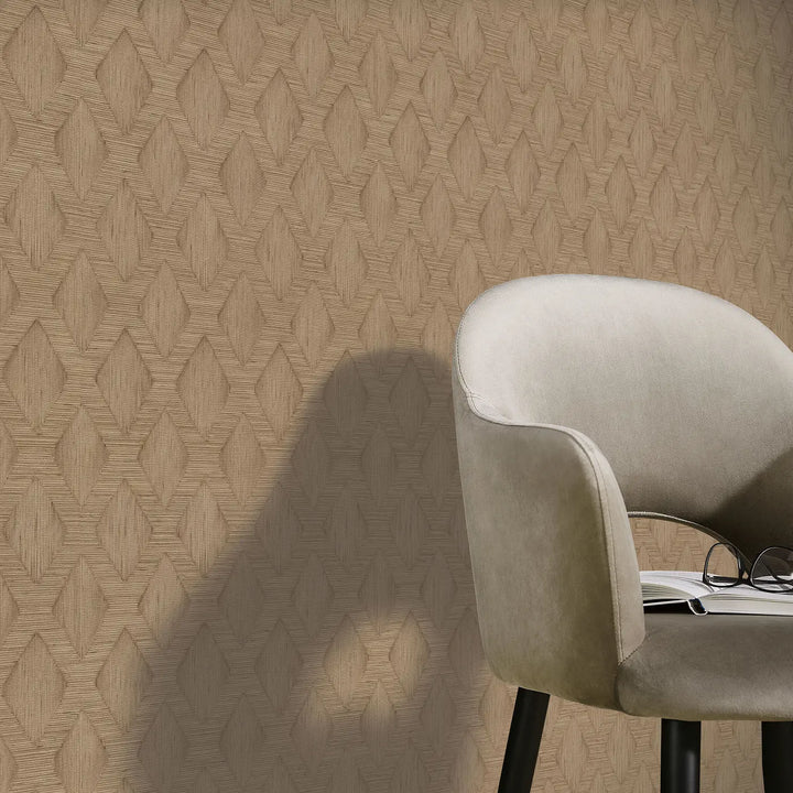 Warm beige non-woven wallpaper with geometric diamond pattern 10509-11 in an interior with a soft armchair