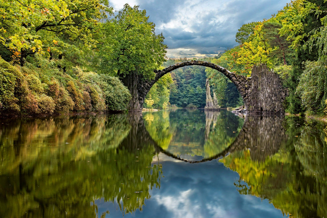 Fototapetes ar arkveidīgu tiltu pāri upei D-ART